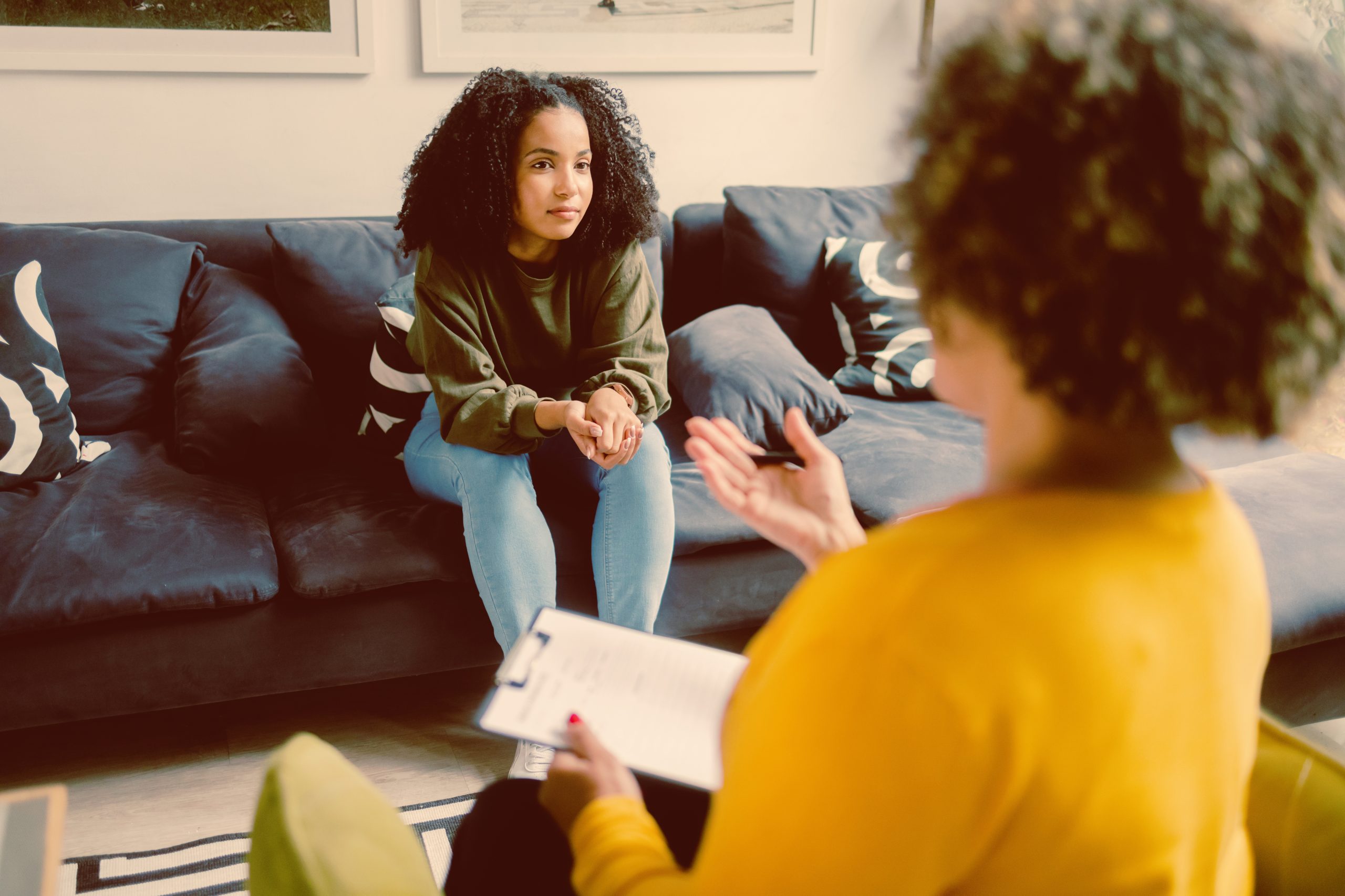 Therapist listening to a client during a counseling session, representing LGBTQ+ affirming therapy in Dallas