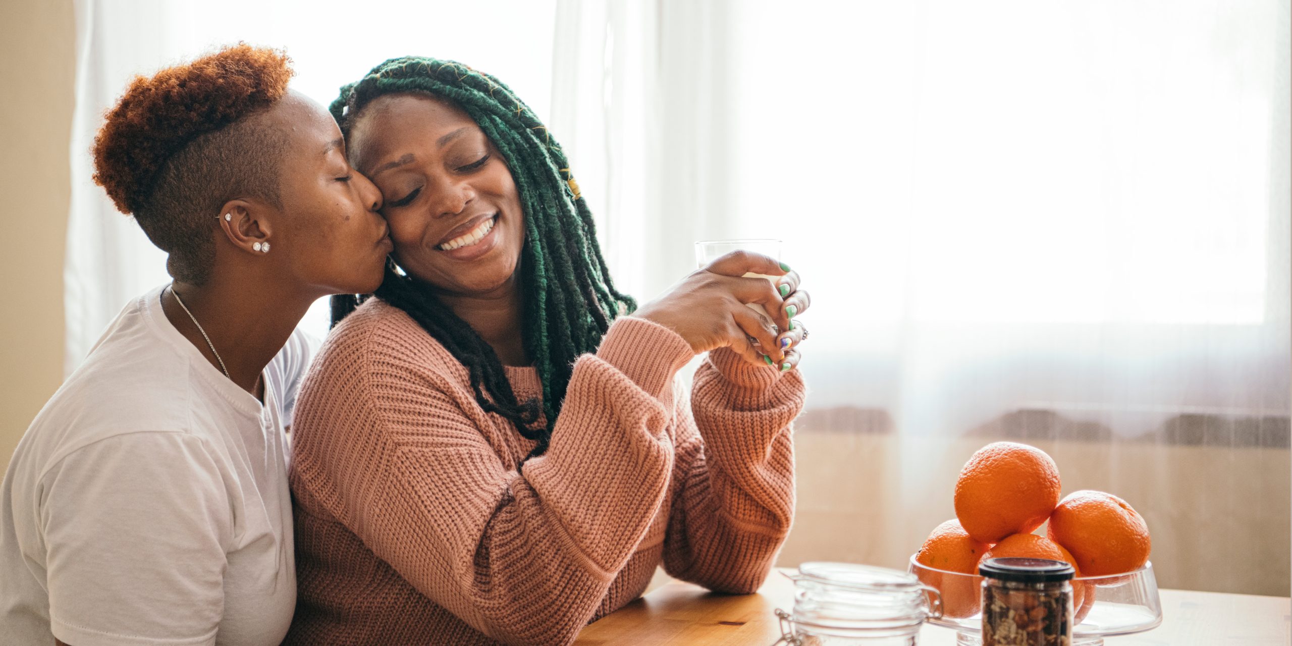 Same-gender couple sharing a loving moment at home, illustrating emotional intimacy and relationship connection.